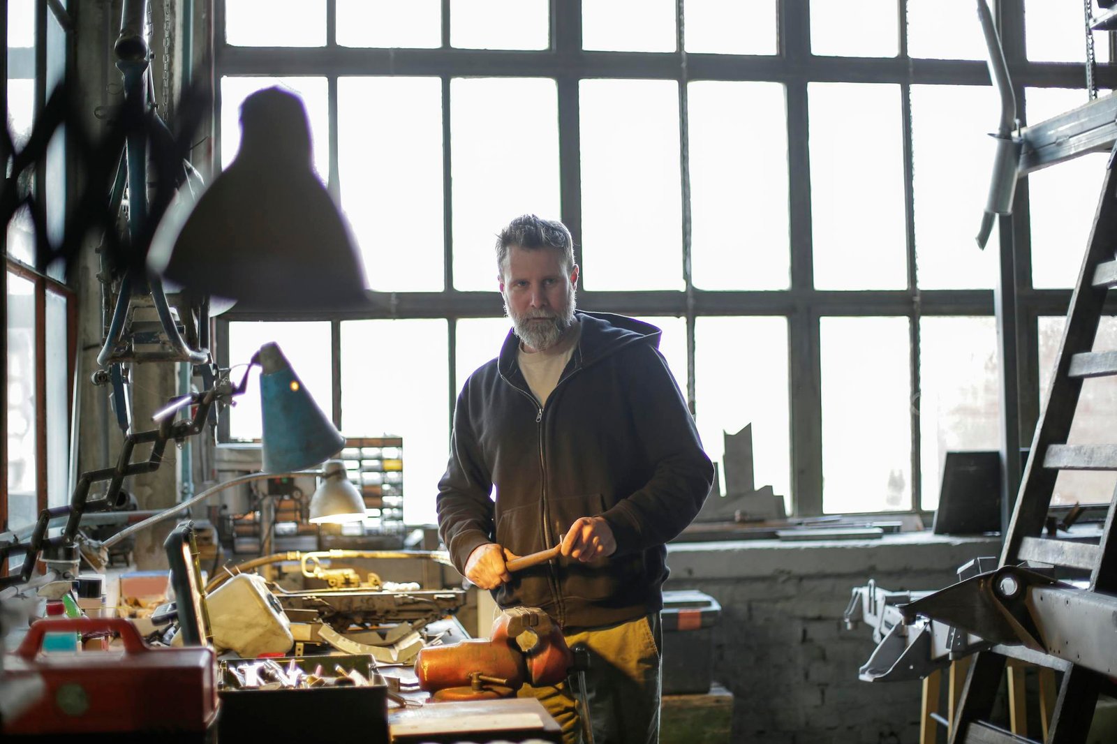 Serious adult mechanic working at workbench in workshop